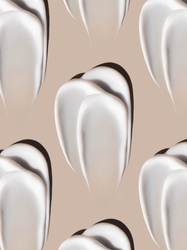 cosmetic smears of creamy texture on a pastel beige background